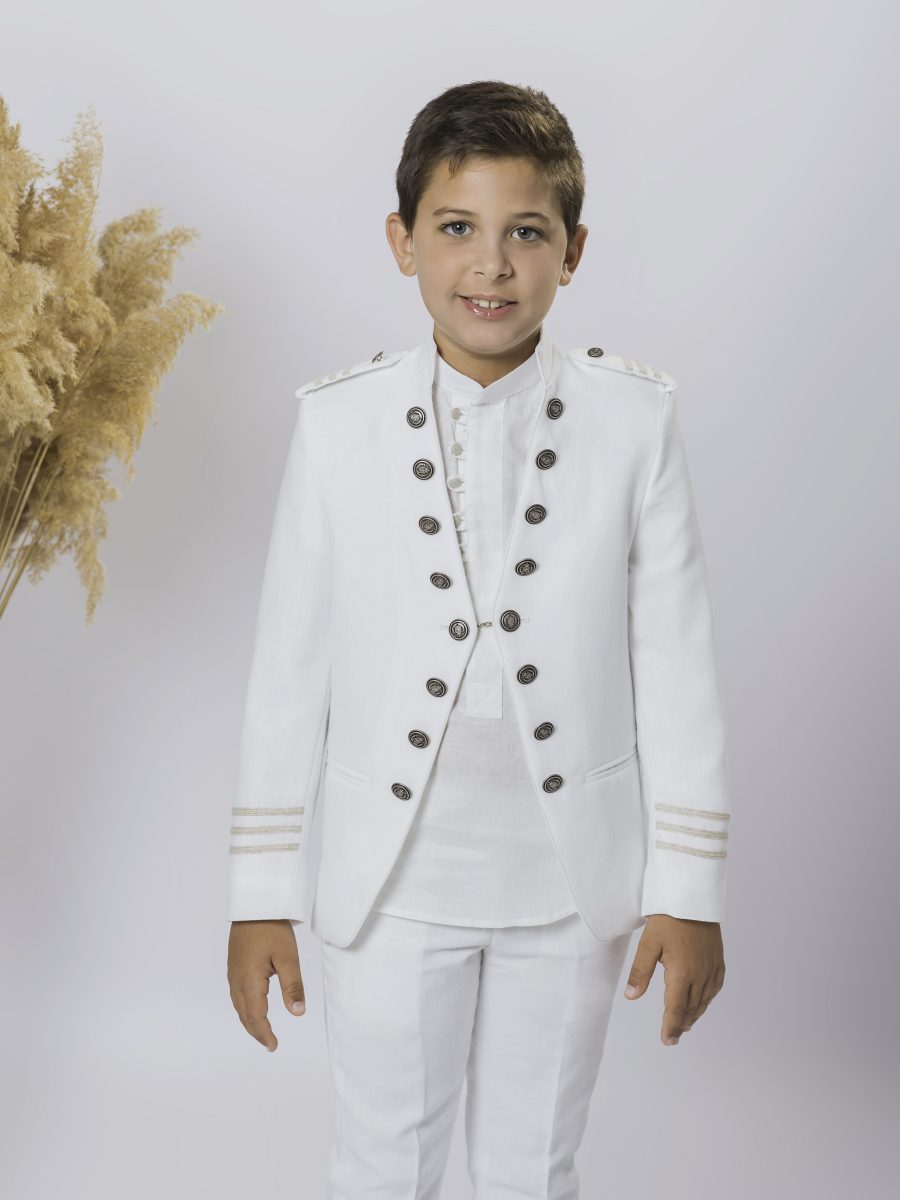 Traje blanco de comunión con chaqueta de doble botonadura oscura, hombreras blancas y galones dorados en los puños, combinado con pantalón blanco.