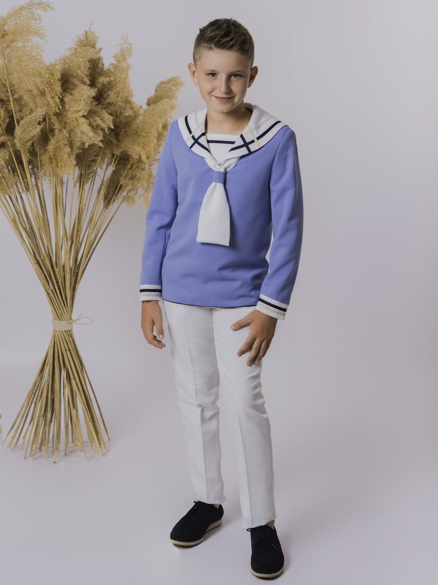 Conjunto marinero de comunión con blusa azul aciano, cuello bicolor blanco y azul marino, lazo blanco y pantalón largo blanco.