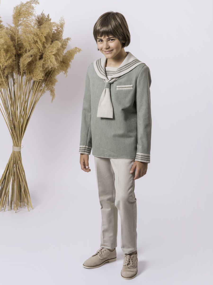 Conjunto marinero de comunión con blusa verde salvia, cuello y corbata beige champán, franjas claras en los puños y pantalón beige.
