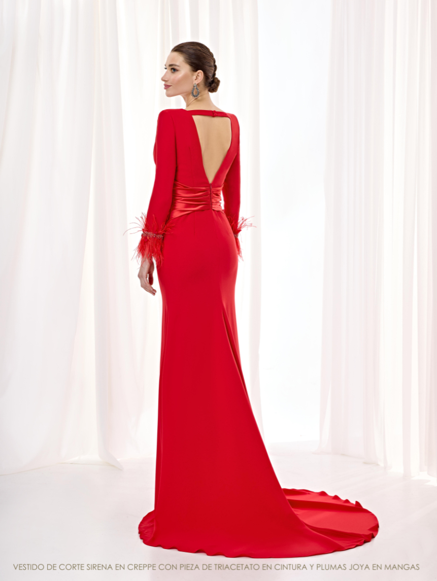 Espalda con gran escote en V del vestido rojo de Esthefan, con faja cruzada, puños de plumas y una cola larga.