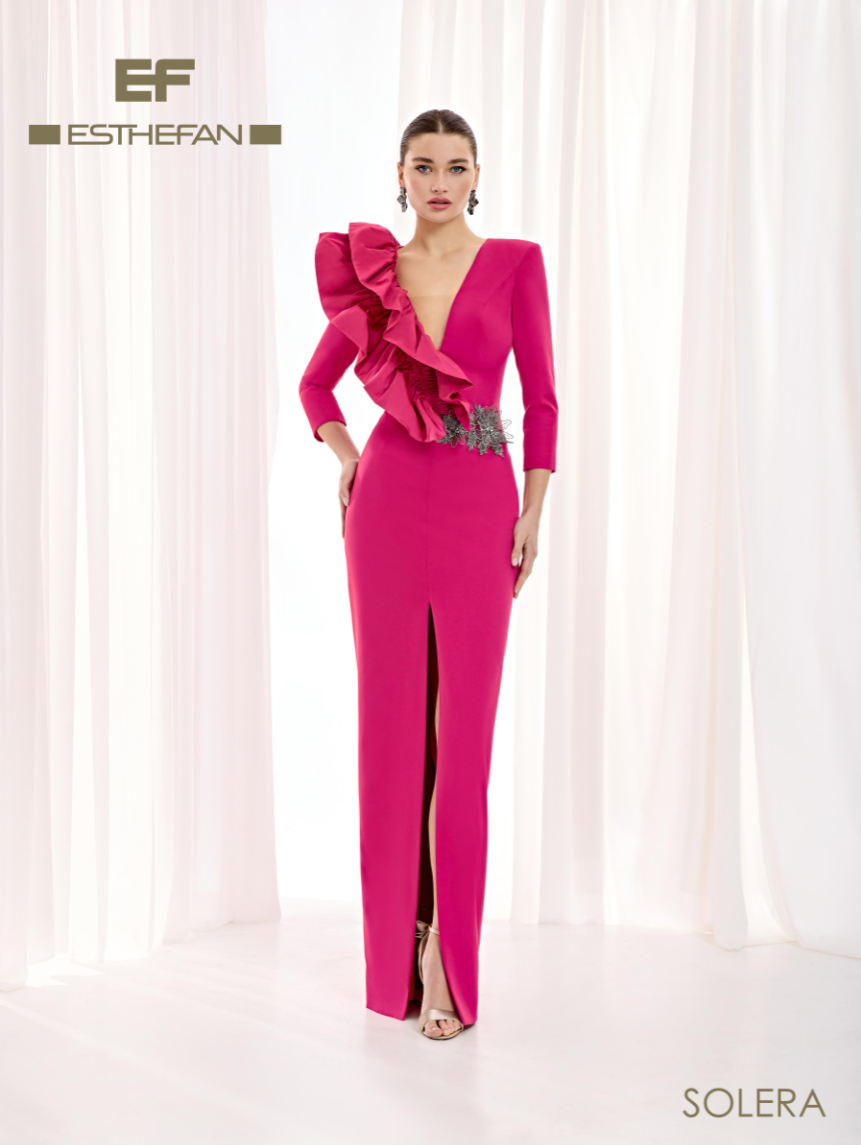 Vestido de Esthefan con gran volante escultórico alrededor del escote en V, mangas tres cuartos y aplicación plateada en un lateral de la cintura.