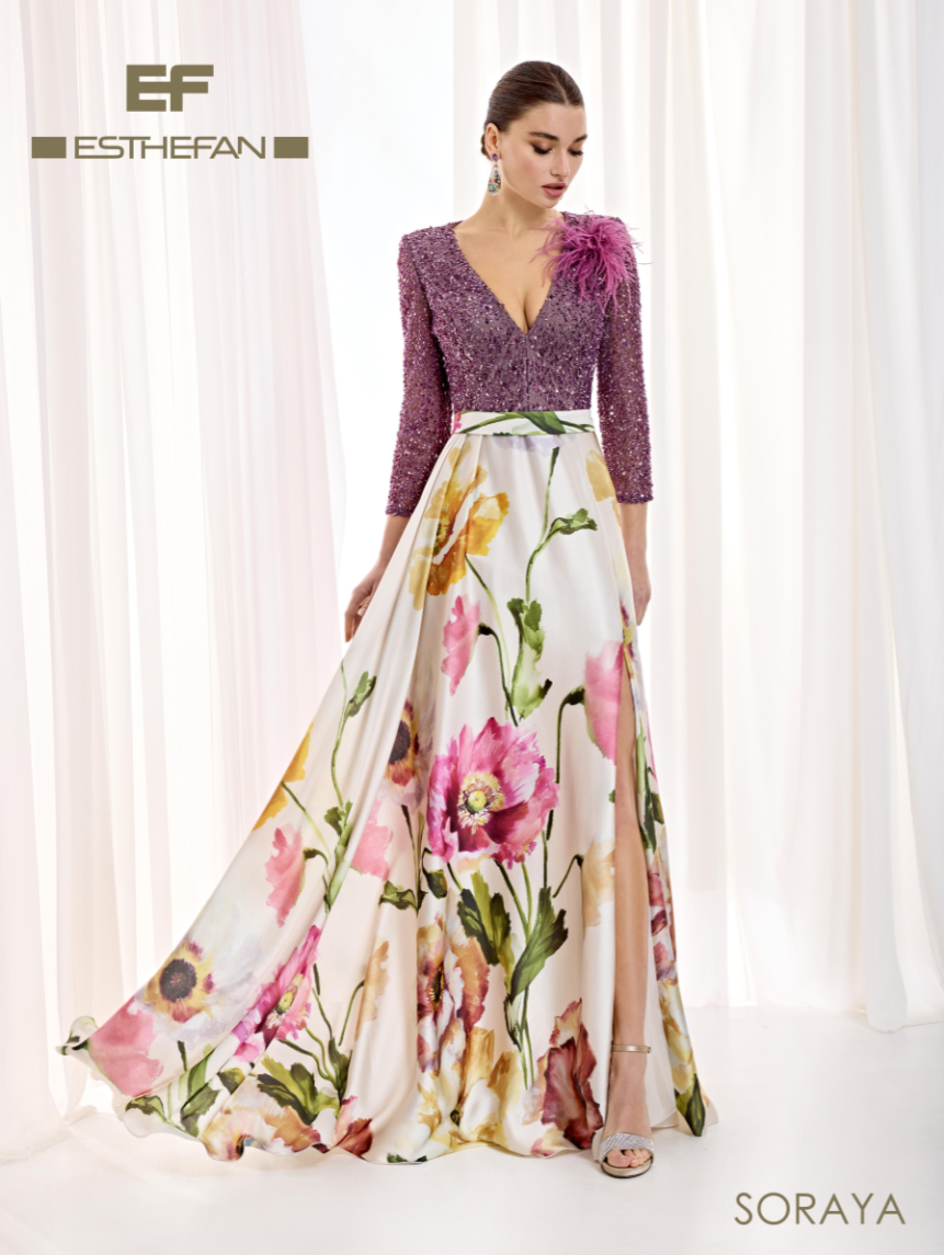 Vestido de Esthefan con cuerpo morado de lentejuelas, plumas en un hombro y falda amplia de estampado floral con abertura lateral.