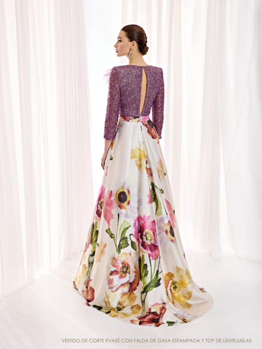 Espalda del vestido de Esthefan con pequeña abertura sobre el cuerpo de lentejuelas, plumas en un hombro y falda floral amplia.