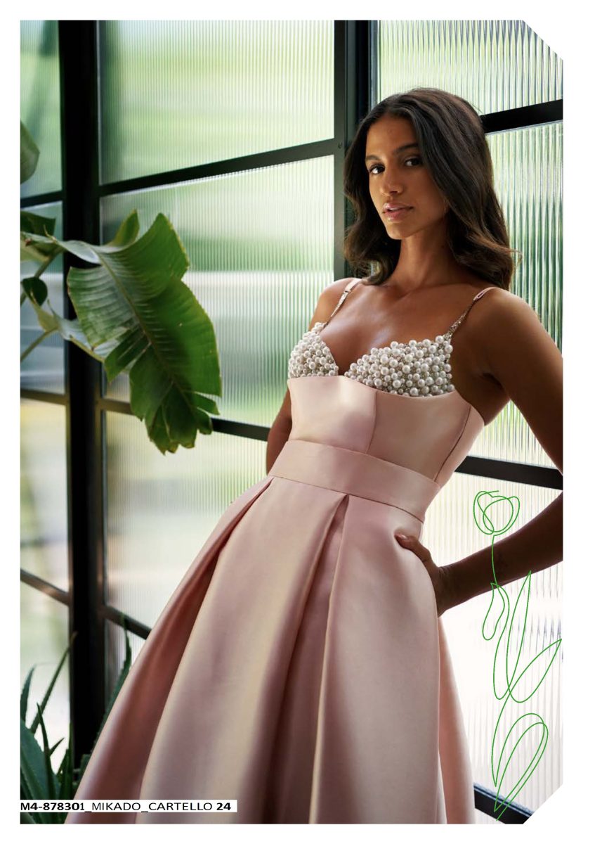 Detalle del bustier de Mischalis con aplicaciones esféricas de efecto perla, tirantes finos y comienzo de una falda con pliegues.