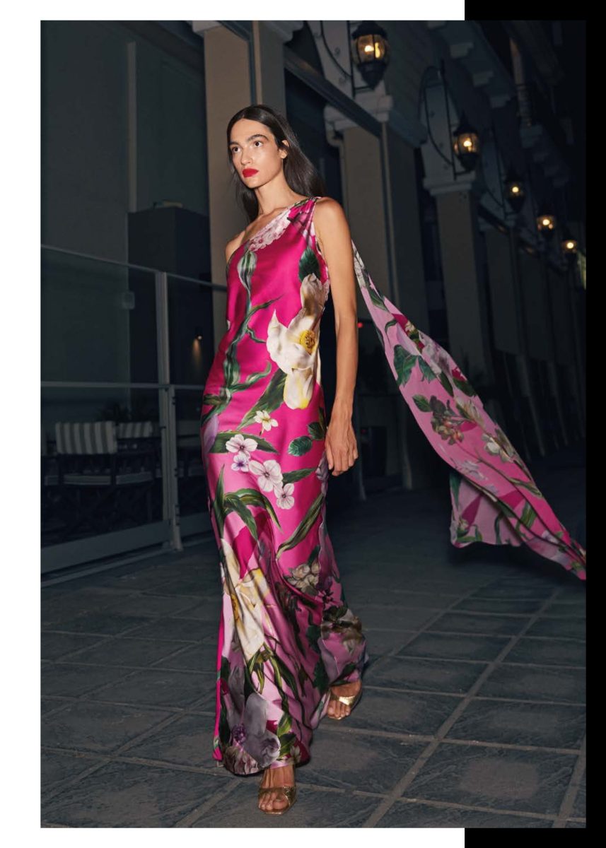 Vestido largo fucsia de Mischalis con estampado botánico de gran tamaño y capa estampada que cae desde un solo hombro.