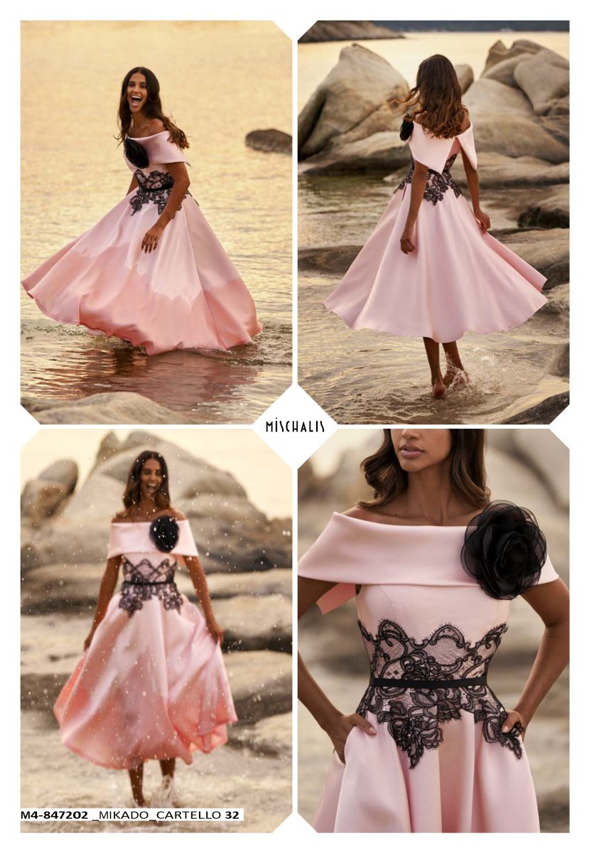 Vestido rosa palo de Mischalis con capelina sobre los hombros, gran flor negra en el escote y contraste de encaje en la cintura.