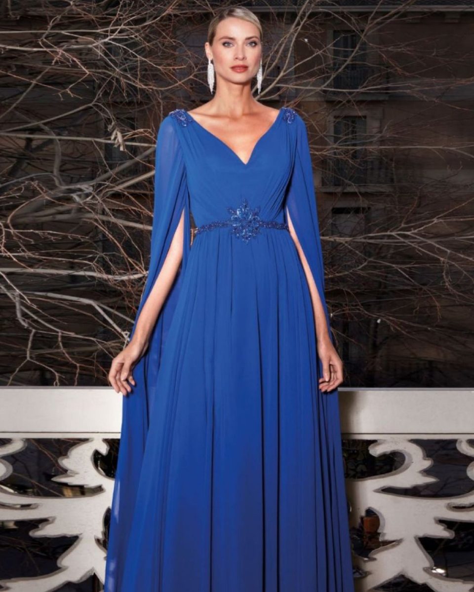 Vestido largo azul royal de Susanna Rivieri con mangas capa, escote en V y aplicación floral con pedrería en la cintura.