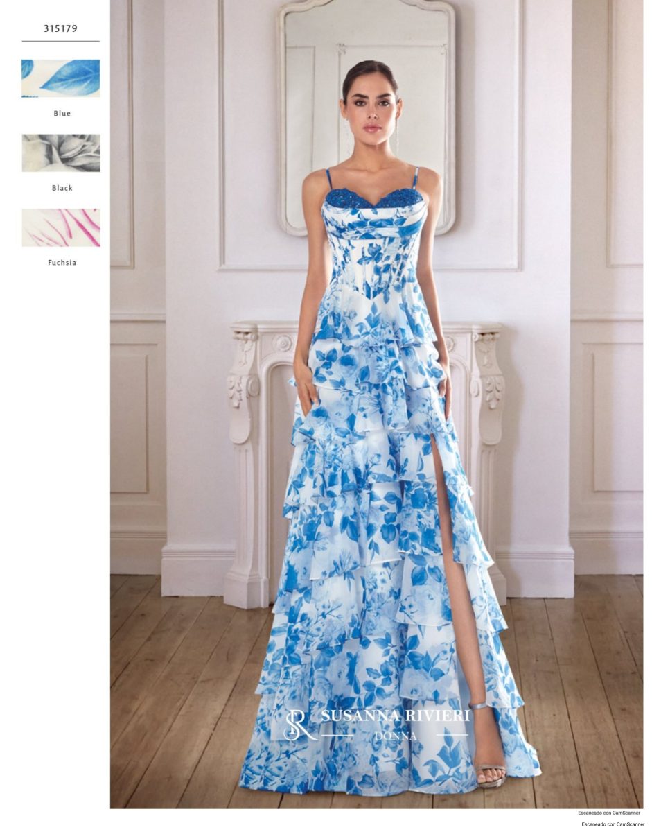 Vestido largo blanco de Susanna Rivieri con flores azules, cuerpo de escote corazón y tirantes finos, y falda de volantes con abertura.